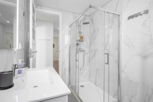 biała łazienka z prysznicem i umywalką w obiekcie WHome Hideaway Family Apartment #2 w Lizbonie