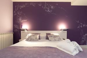 a bedroom with a large bed with purple walls at Ur-Alde in San Sebastián