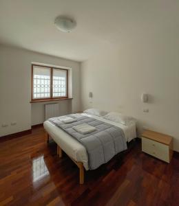 a bedroom with a large bed and a wooden floor at Richi Rent 01 in Verona