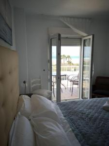 a bedroom with a bed and a view of the ocean at Apartamento Dos Faros in Conil de la Frontera