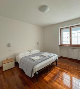 a white bedroom with a bed and a wooden floor at Richi Rent 01 in Verona