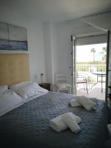 a bedroom with a large bed with two towels on it at Apartamento Dos Faros in Conil de la Frontera