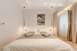 a white bedroom with a large bed with two pillows at Luxury Rooms L'Avenue 2 Split in Split