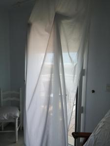 a bed with a white canopy in a bedroom at Apartamento Dos Faros in Conil de la Frontera