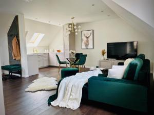 a living room with a green couch and a kitchen at DeerHome Apartment in Czarny Dunajec