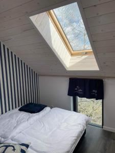 a bedroom with a bed and a skylight in the ceiling at Dom w Zatoce in Piecki