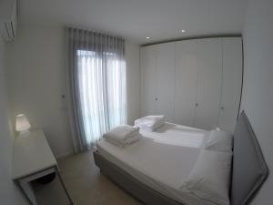 a white bedroom with a mirror and a bed at Suite Serenissima bilocale con terrazzo frontemare - Agenzia Cocal in Caorle