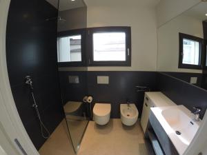 a bathroom with two toilets and a sink and a shower at Suite Serenissima bilocale con terrazzo frontemare - Agenzia Cocal in Caorle +9 photos
