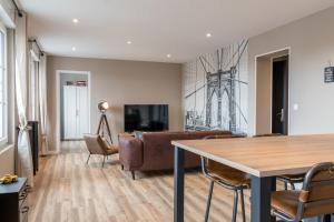 a living room with a table and a couch at voyageurs in Valognes