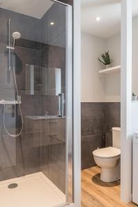 La salle de bains est pourvue d'une douche et de toilettes. dans l'établissement voyageurs, à Valognes