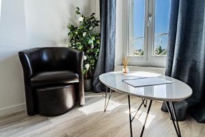 una silla y una mesa en una habitación con ventana en Domaine de l'Aufrene, en Hyères