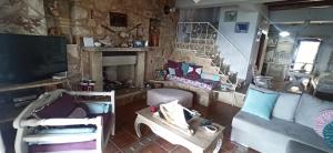 un soggiorno con divani, TV e camino di Elouthia Residence with Sea View and Hot Tub a Tsoutsouros