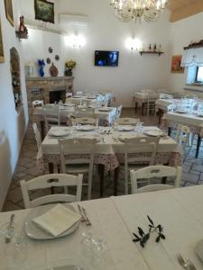 a dining room with white tables and white chairs at Tenuta De Luca in Sannicandro Garganico