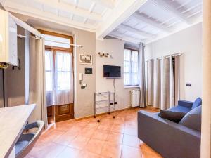 sala de estar con sofá y TV en MYHOUSE INN LE ROSINE - Affitti Brevi Italia en Turín