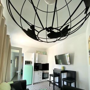 a living room with a kitchen with a large chandelier at Maria's Doll House in Adelianos Kampos