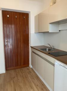 a kitchen with a sink and a wooden door at Obermais garden living in Merano +8 photos