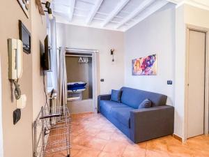 sala de estar con sofá azul y TV en MYHOUSE INN LE ROSINE - Affitti Brevi Italia, en Turín