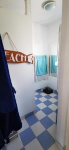 een badkamer met een blauwe en witte geruite vloer bij Bulle Marine in Calais