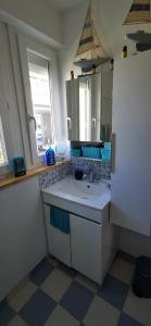 een badkamer met een wastafel en een spiegel bij Bulle Marine in Calais