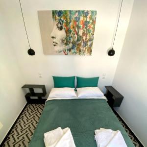 a bedroom with a green bed with a painting on the wall at Maria's Doll House in Adelianos Kampos