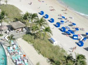 einen Blick über den Strand mit Menschen und Sonnenschirmen in der Unterkunft On the Ocean in Miami Beach