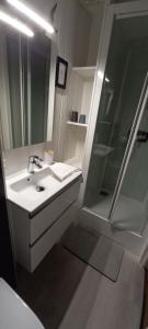 a white bathroom with a sink and a shower at Le Relais De Launay in Ploubazlanec