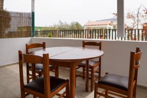 un tavolo in legno e sedie sul balcone. di Aelia House a Città di Kos