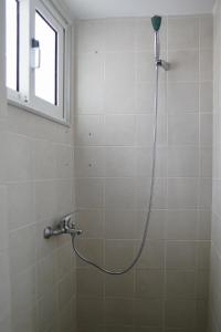 a shower with a hose in a bathroom at Aelia House in Kos