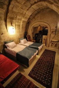 two beds in a room in a stone cave at patisca cave house in cappadocia in Urgup