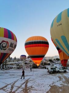 a group of hot air balloons in the snow at patisca cave house in cappadocia in Ürgüp