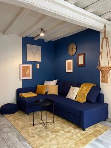 een blauwe bank in een kamer met een blauwe muur bij Bel appartement chic et cosy. in Martres-de-Veyre