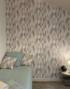 - une chambre avec un lit et un mur géométrique dans l'établissement Bel appartement chic et cosy., à Martres-de-Veyre