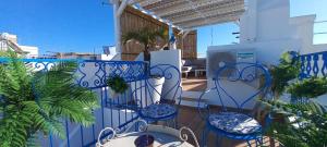 einen Balkon mit blauen Stühlen, Tischen und einem Pool in der Unterkunft Casa Do Pescador in Olhão