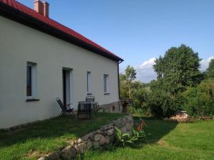 a white house with a table and chairs in the yard at Apartament Wydminy in Wydminy
