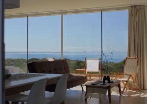 - un salon avec un canapé et une grande fenêtre dans l'établissement Médanos Patagonia, à Las Grutas