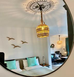 a living room with a couch and birds in a mirror at Beach54 Damp Wellness-Loft in Damp