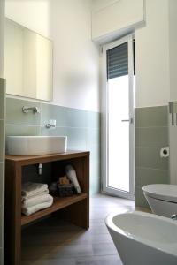 a bathroom with a sink and a tub and a mirror at Provenzale Guest Rooms - Locazione breve in Naples