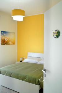 a bedroom with a bed and a yellow wall at Provenzale Guest Rooms - Locazione breve in Naples