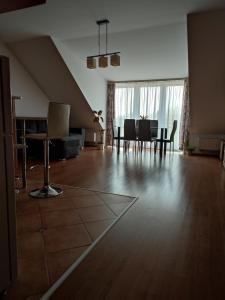 uma sala de estar vazia com uma mesa e cadeiras em LARIX Apartman em Sárvár