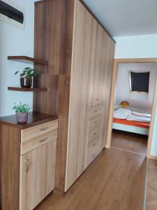 a bedroom with a large wooden closet with a bed at LARIX Apartman in Sárvár