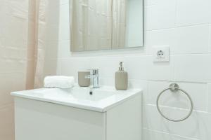 un bagno bianco con lavandino e specchio di New BORODIN FAMILY AB a Lloret de Mar Altre 80 foto