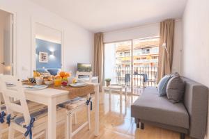 una cucina e un soggiorno con un tavolo e un divano di New BORODIN FAMILY AB a Lloret de Mar