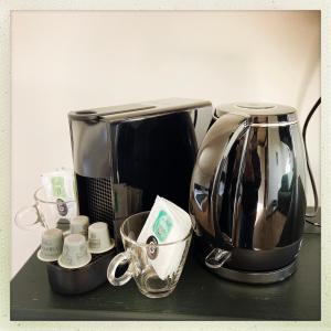eine Theke mit Kaffeemaschine und Tassen darauf in der Unterkunft l'Aod, maison d'hôtes insulaire in Lampaul