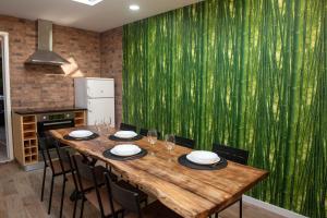 una mesa de madera en una cocina con una pared verde en Furnas Sweet Home, en Furnas