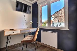 een bureau en een stoel in een kamer met een raam bij Studio Taormina Valenciennes Centre in Valenciennes