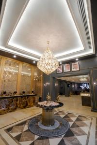 a large lobby with a chandelier and a table at Nishan Hotel in Amman