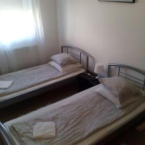 two twin beds in a room with a window at M0 Lakihegy Horgony u 10 in Szigetszentmiklós