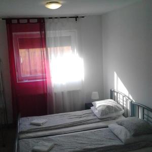 1 dormitorio con 1 cama con puerta roja en M0 Lakihegy Horgony u 10, en Szigetszentmiklós