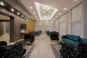 a living room with couches and chairs and a television at Nishan Hotel in Amman