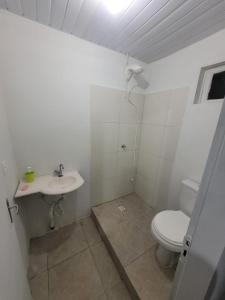 Baño blanco con aseo y lavamanos en Pousada Max House entre Praias de SFS en São Francisco do Sul